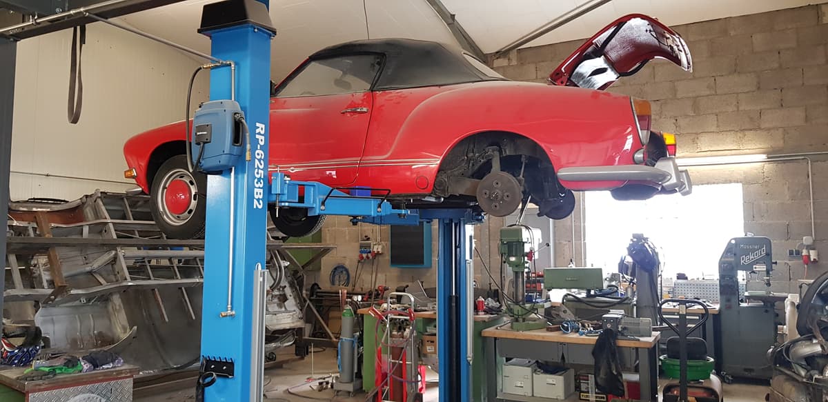 Werkstatt mit Auto auf Hebebühne